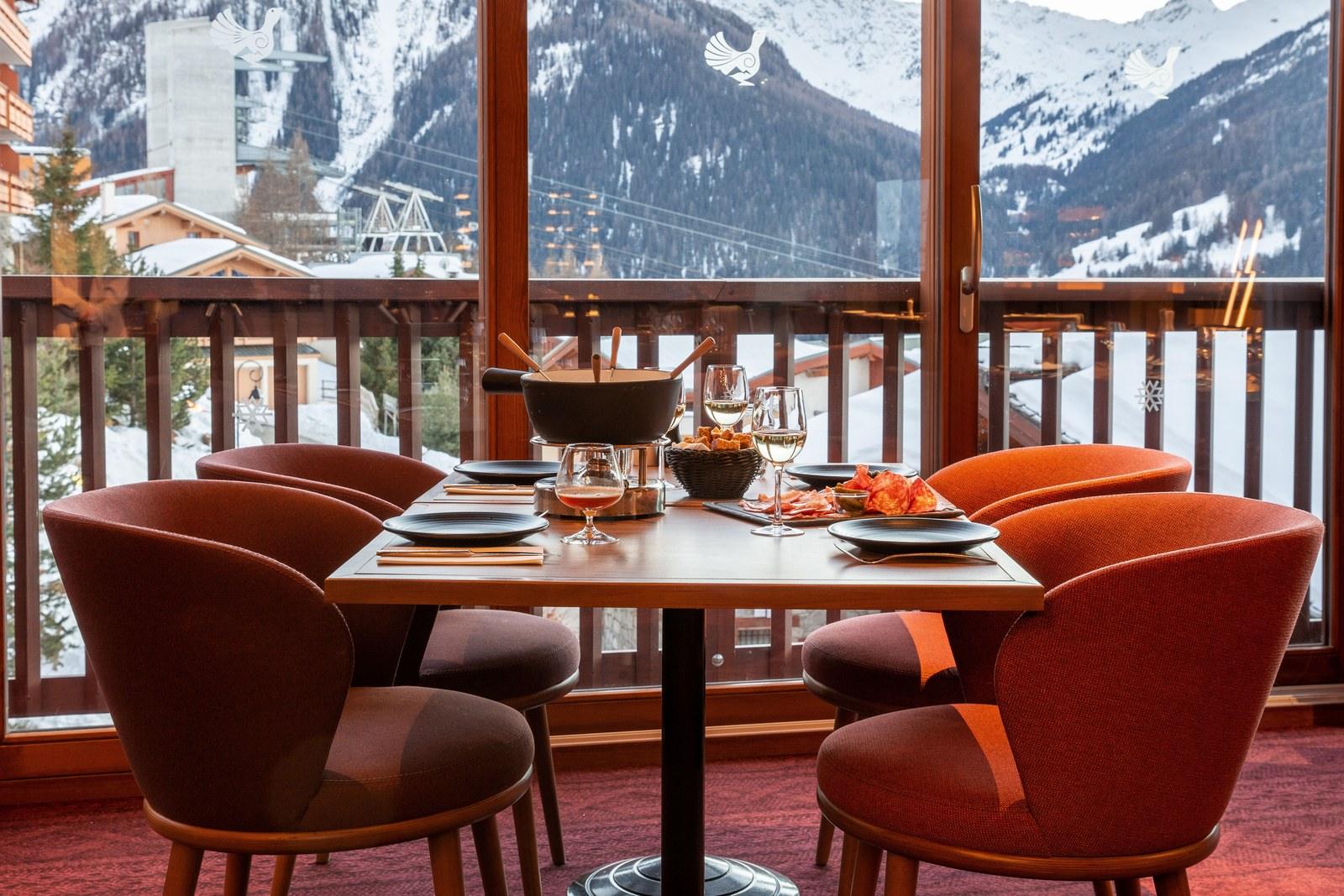 Fondue table beside a snowy mountain view at Club Med Peisey-Vallandry