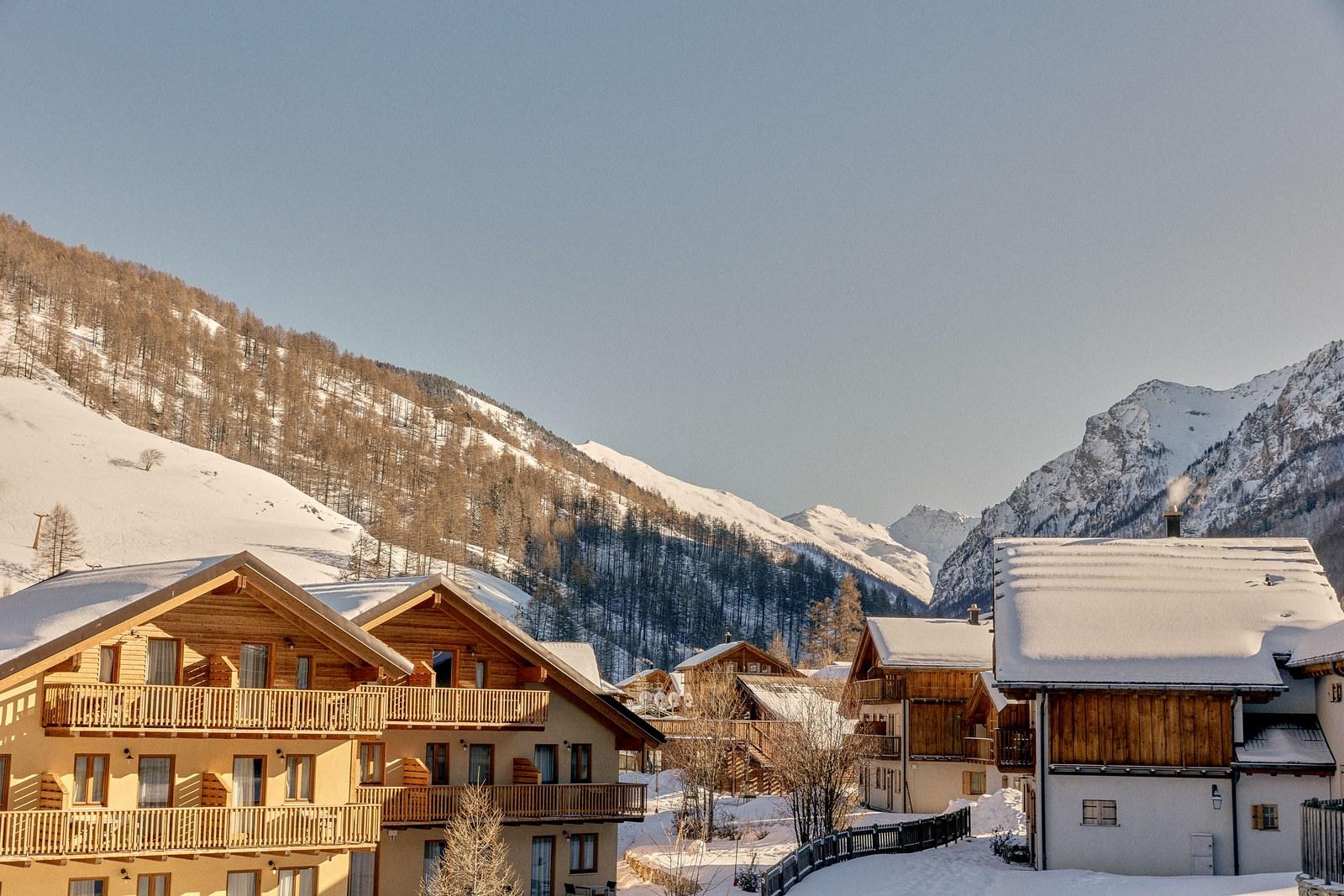 Chalet-style buildings at Club Med Pragelato Sestriere overlooking the valley