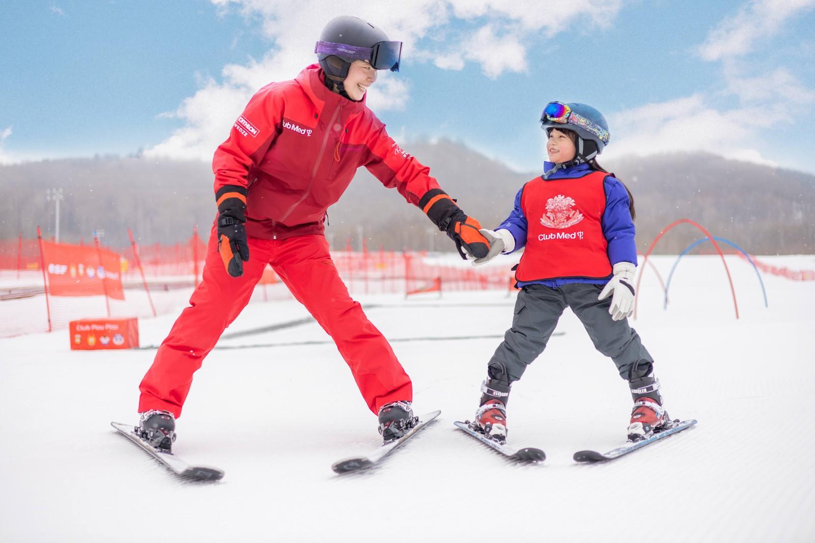 Child learning to ski with an instructor at Club Med Changbaishan
