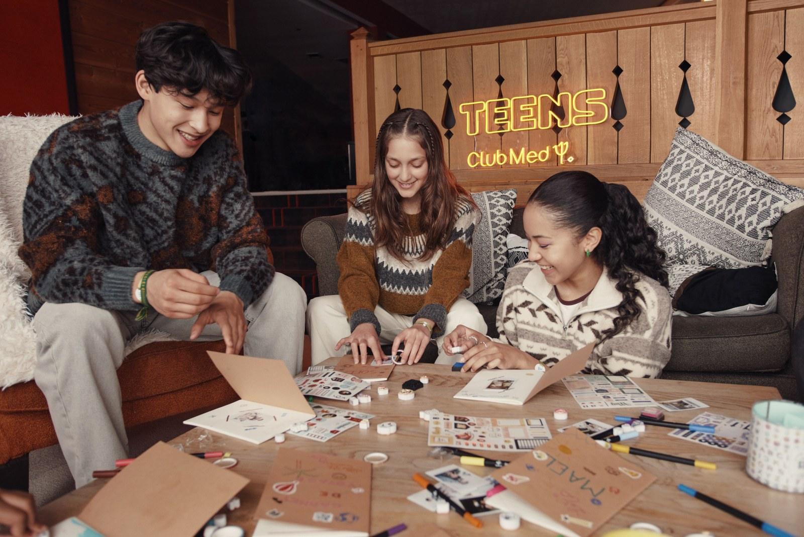 Teenagers crafting around a table in a Club Med teens lounge
