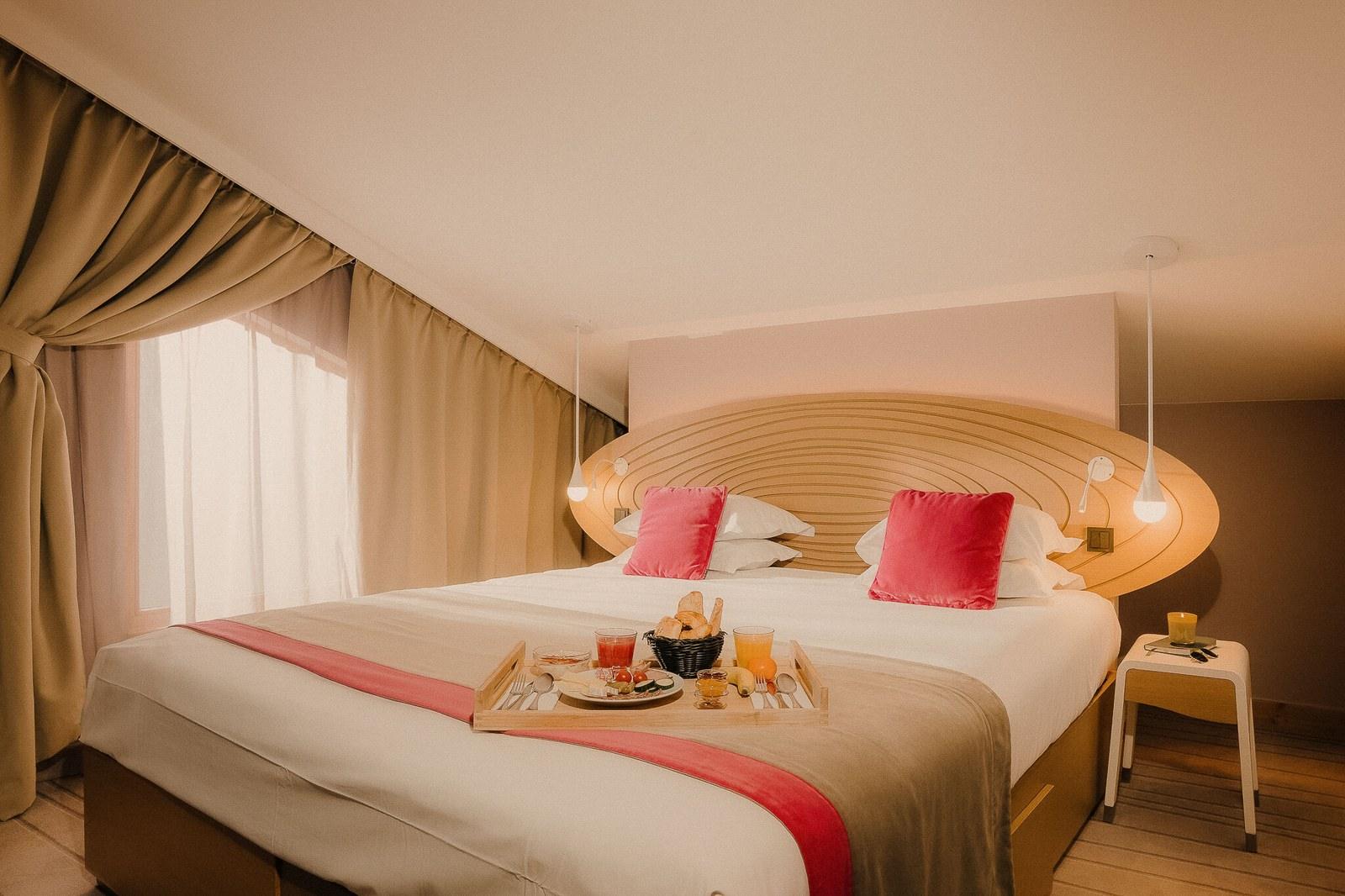 Guest room with sculpted timber headboard at Club Med Val Thorens Sensations