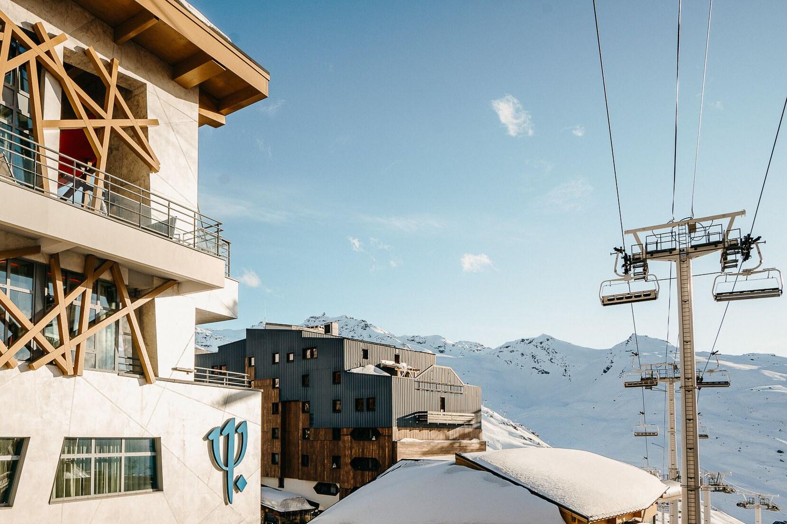 Snow-covered Club Med Val Thorens Sensations beside a chairlift and mountain slopes
