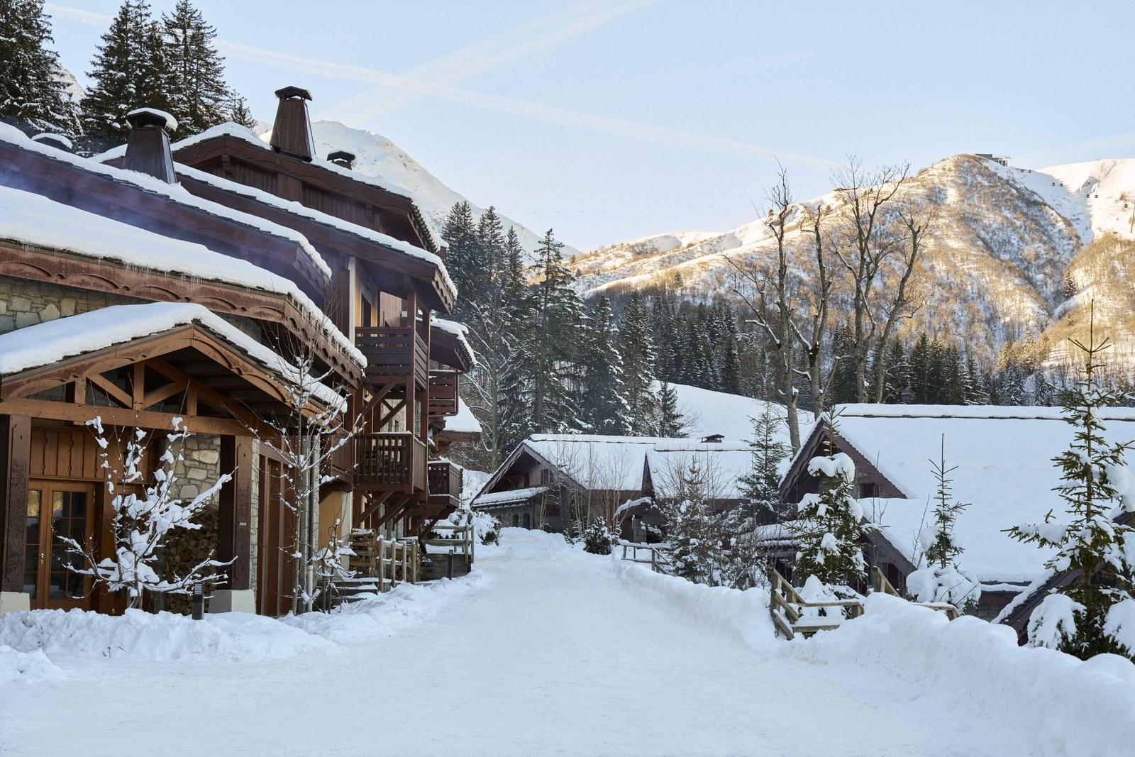Snowy lane beside timber chalets at Valmorel Chalet-Apartments