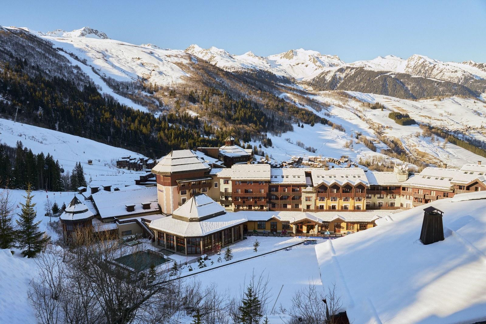 Snow-covered Club Med Valmorel beneath the mountain skyline