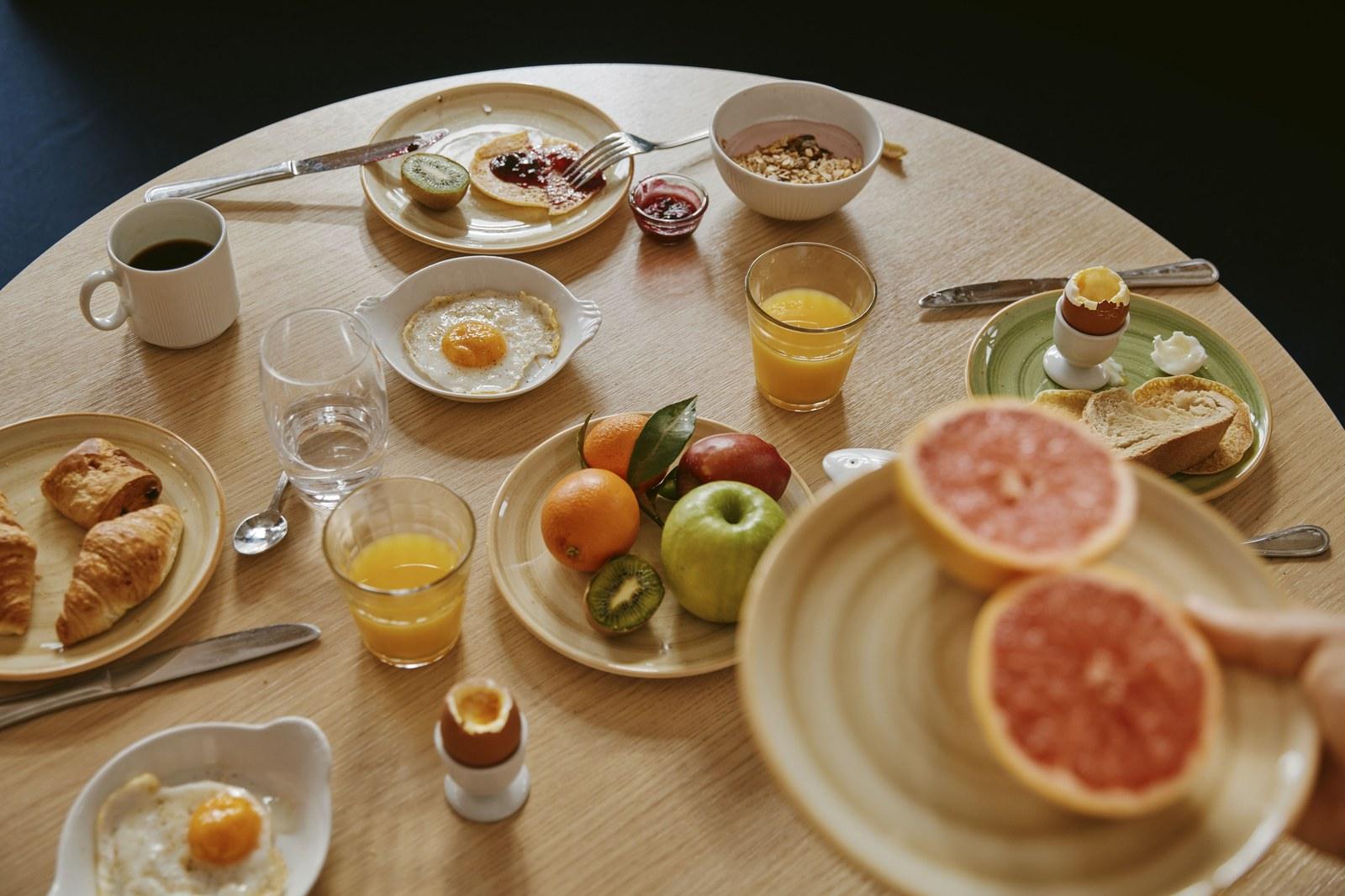 Breakfast table with eggs, pastries, fruit, juice and coffee at Club Med Serre Chevalier