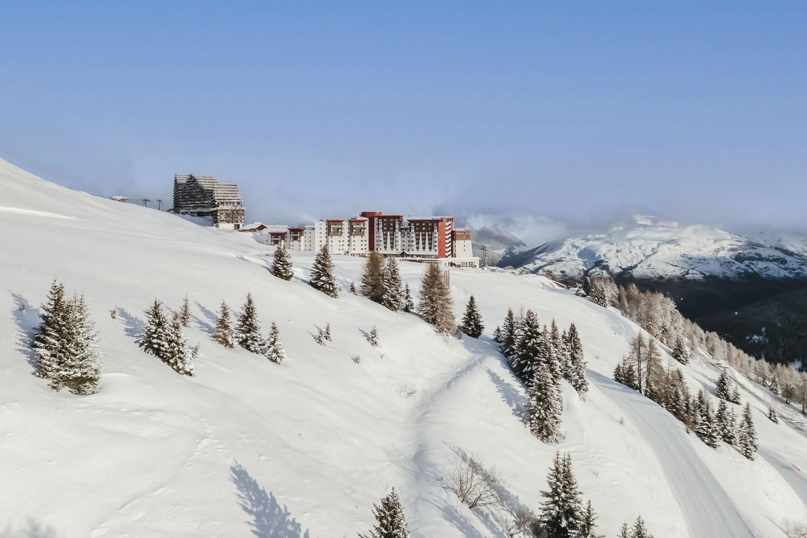 Club Med La Plagne 2100 above snow-covered slopes and fir trees