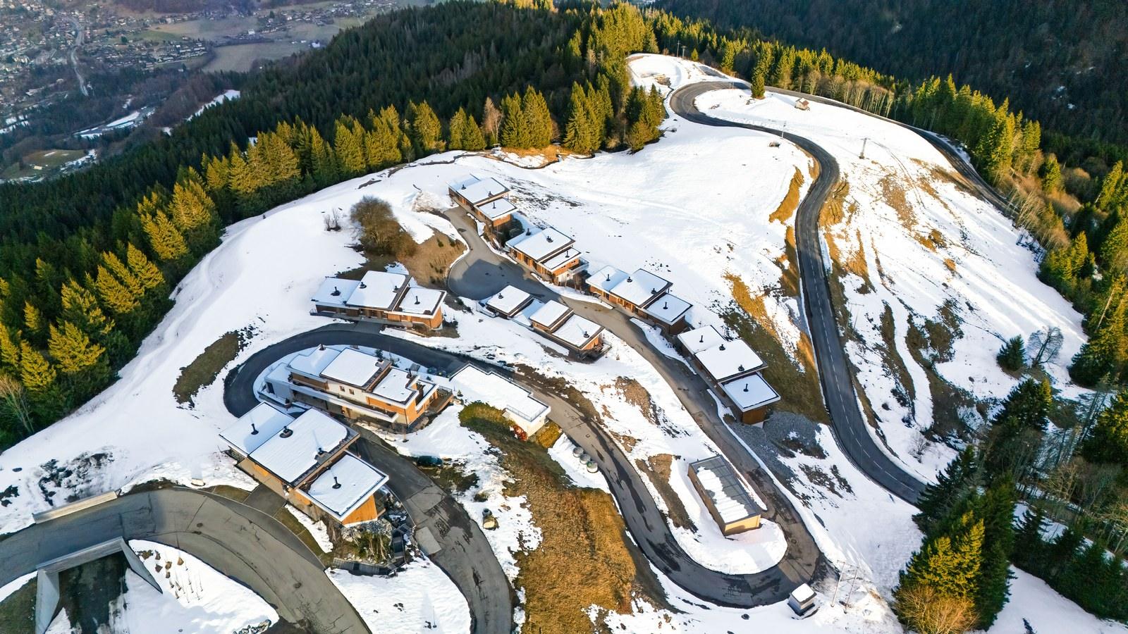 Winter aerial view of the Grand Massif Chalet-Apartments and access road