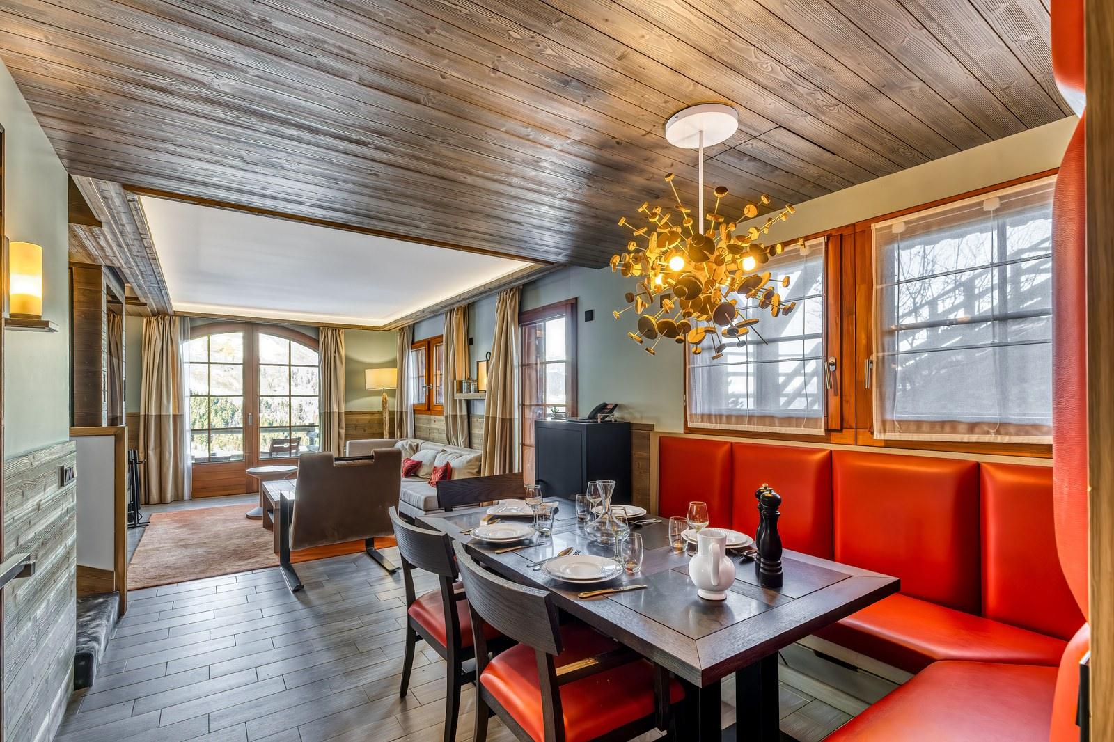 Private chalet dining area with a red banquette at Valmorel Chalet-Apartments