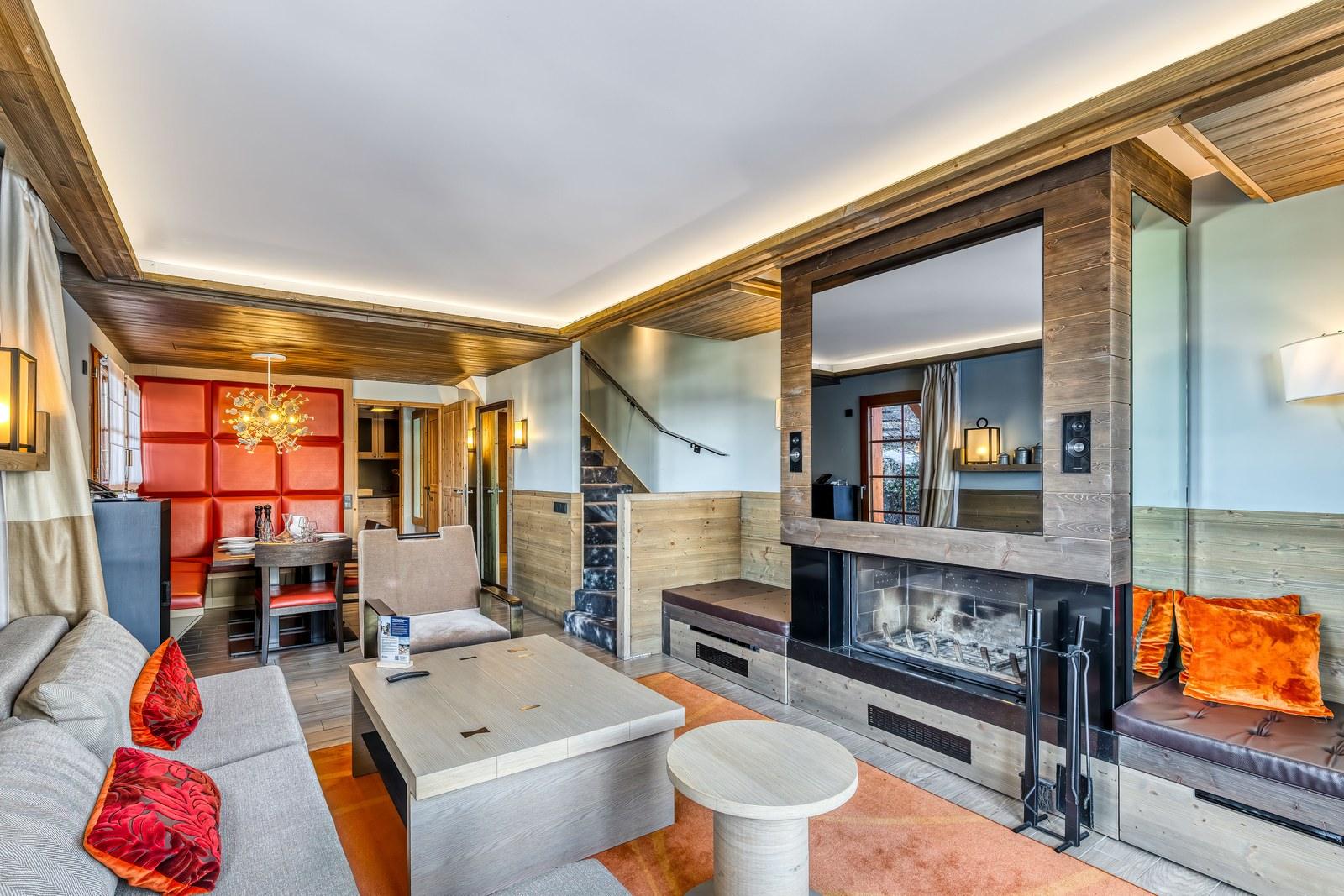 Private chalet lounge with a fireplace and dining nook at Valmorel Chalet-Apartments