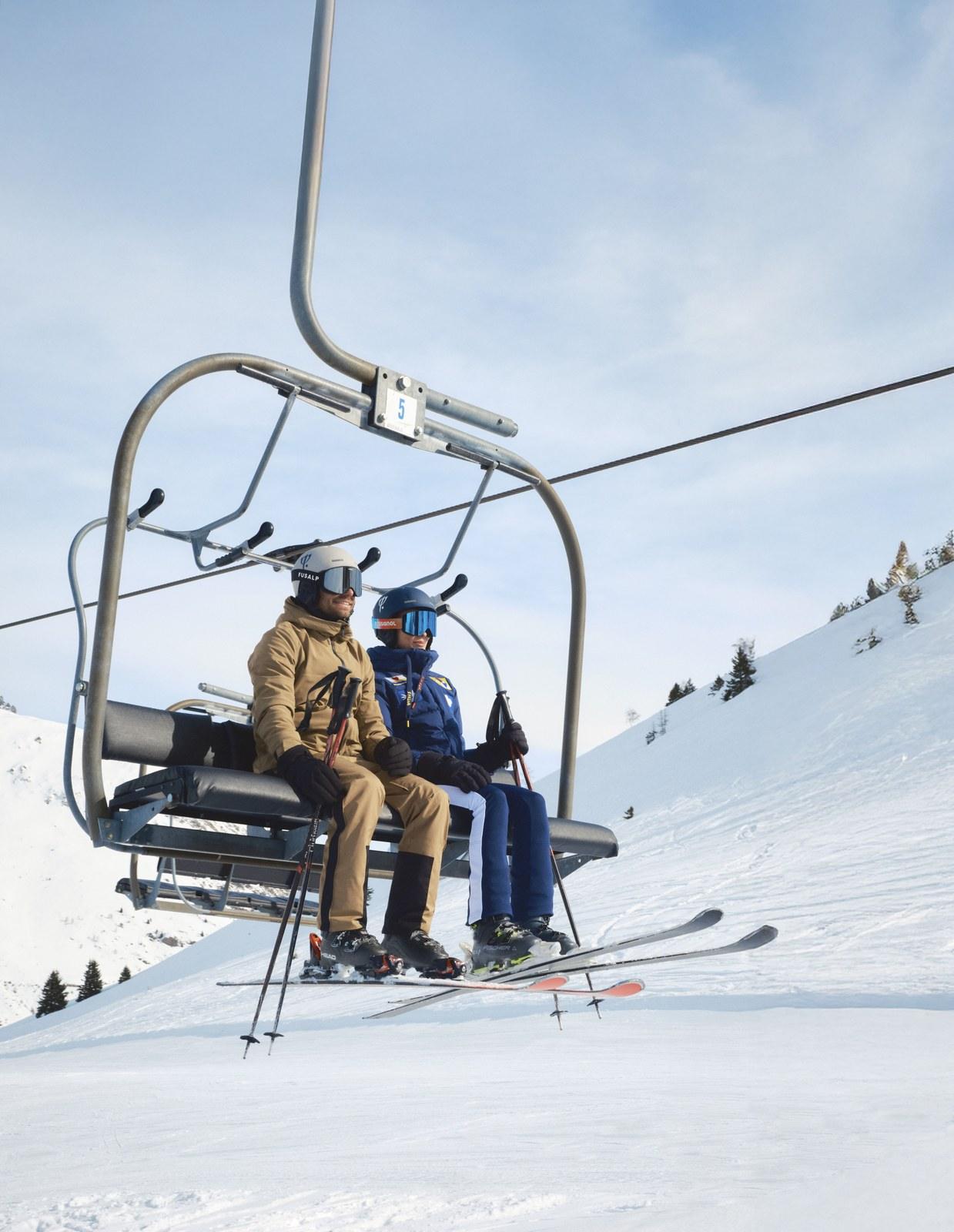 Skiers riding a chairlift at Alpe d’Huez