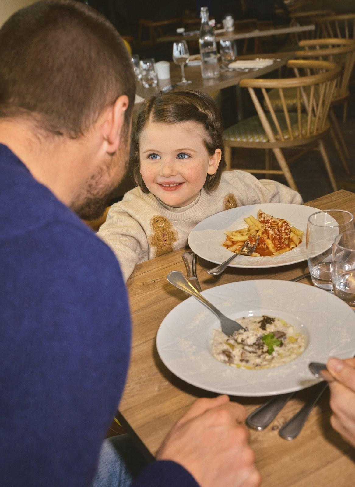 Child and parent sharing a meal at Club Med Alpe d’Huez