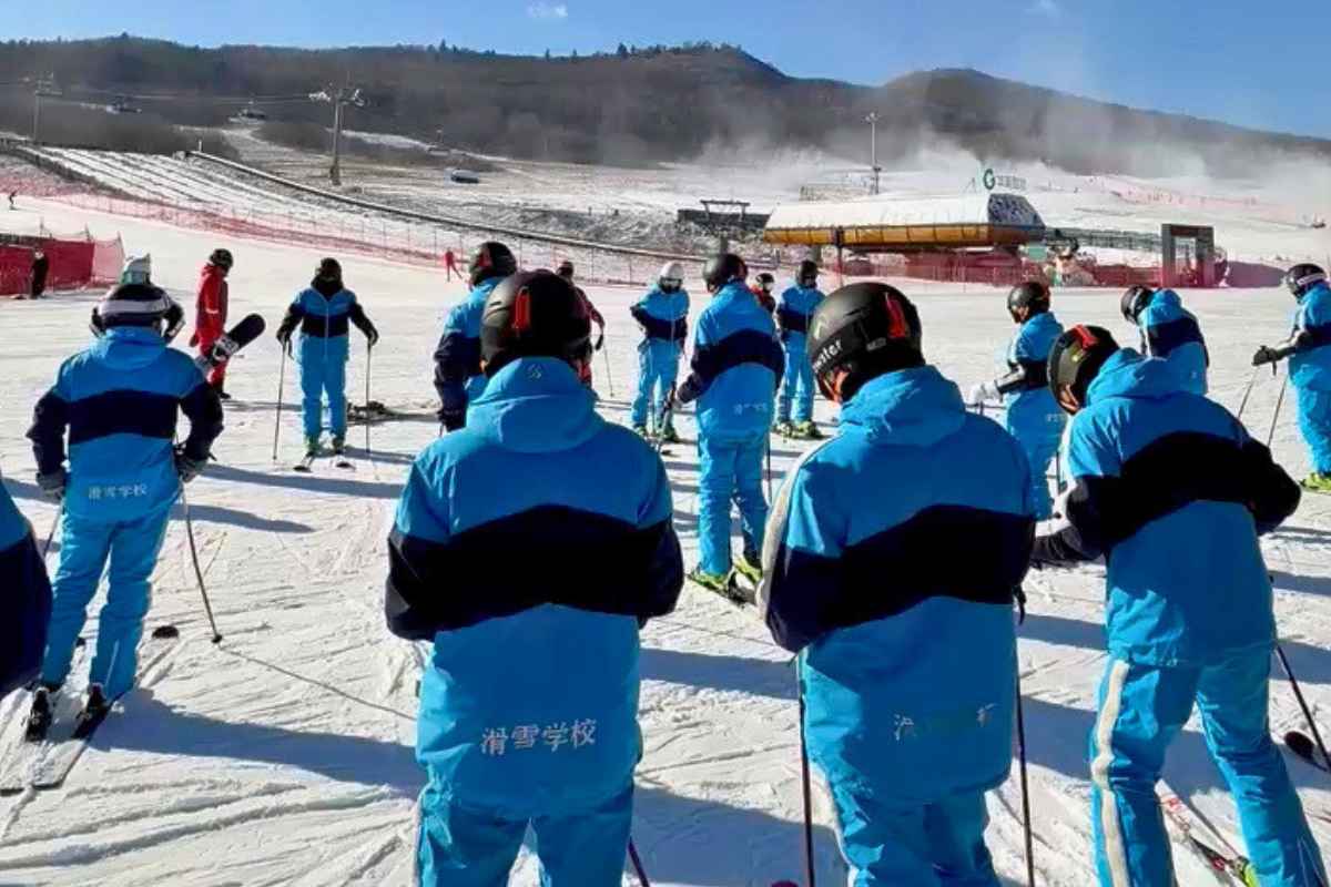 A group of skiers in blue ski-school clothing on a snowy slope in China